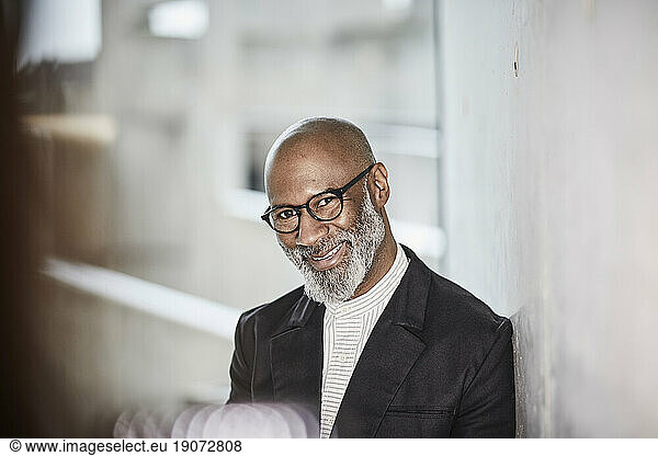 Portrait of smiling mature businessman with grey beard wearing glasses