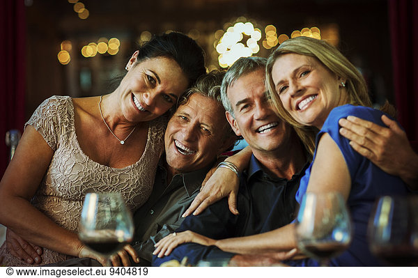 Portrait of smiling mature couples sitting together in restaurant