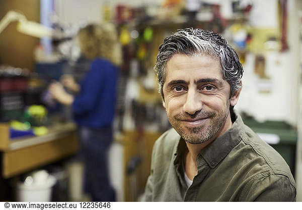 Portrait of smiling mature male volunteer at workshop