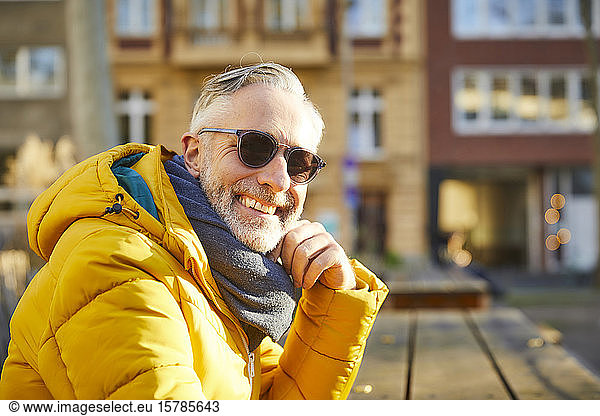 Portrait of smiling mature man wearing sunglasses in the city