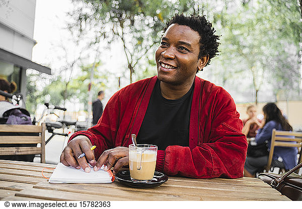 Portrait of smiling mature man working at street cafe