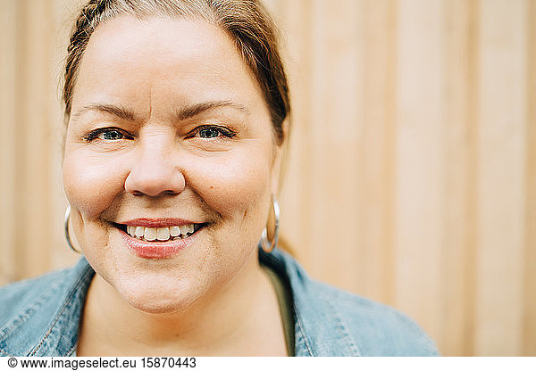 Portrait of smiling mature woman against wall