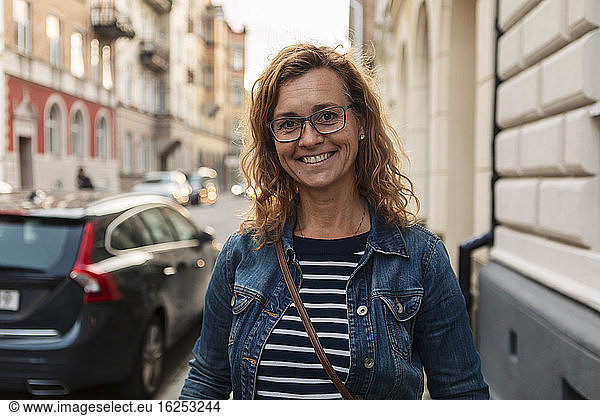 Portrait of smiling mature woman in city during weekend