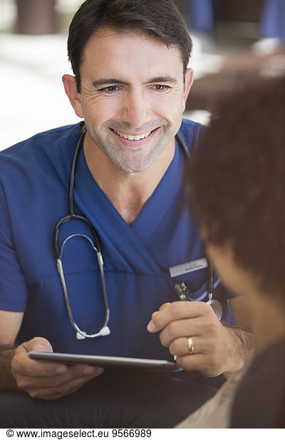 Portrait of smiling mid adult doctor holding tablet pc