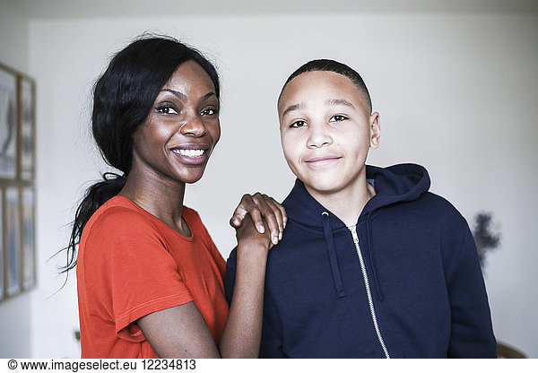 Portrait of smiling mother and son at home