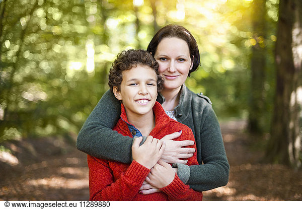 Portrait of smiling mother and son in the autumnal forest