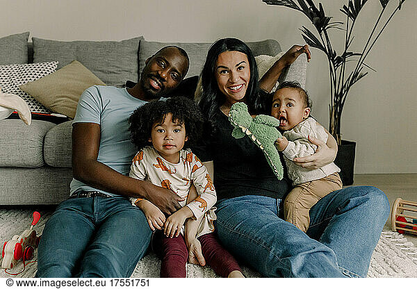 Portrait of smiling multiracial family in living room
