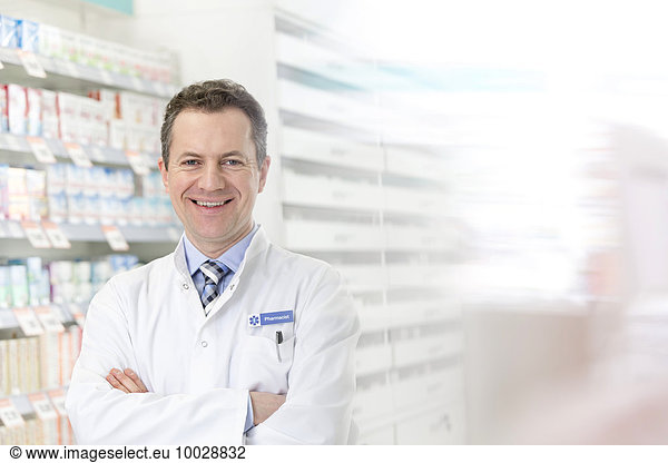 Portrait of smiling pharmacist with arms crossed in pharmacy