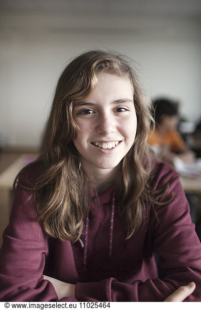 Portrait of smiling schoolgirl (12-13) in classroom