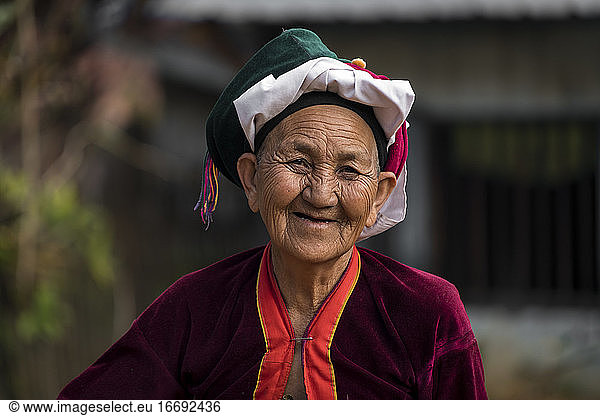 Portrait of smiling senior woman of Palong tribe wearing headwear  near Hsipaw  Myanmar