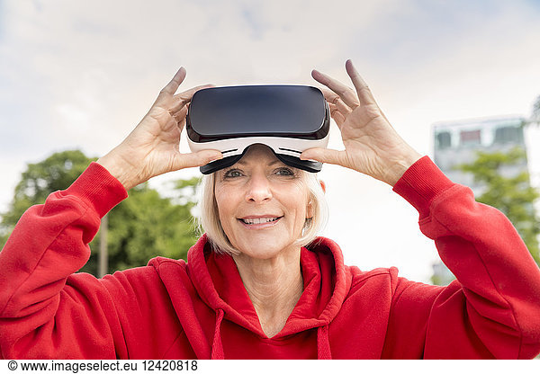 Portrait of smiling senior woman wearing VR glasses