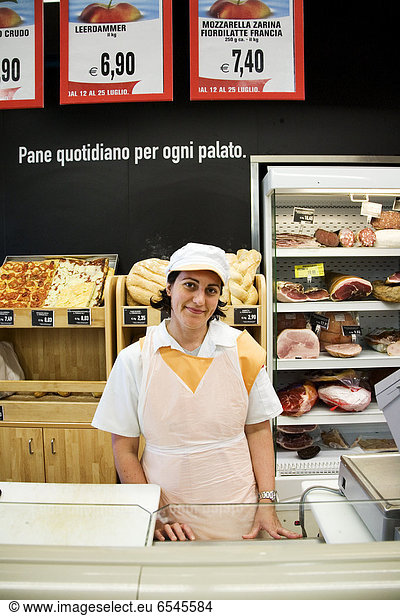 Portrait of smiling shop assistant in shop with italian food