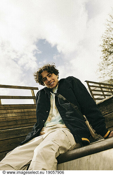 Portrait of smiling teenage boy sitting on steps