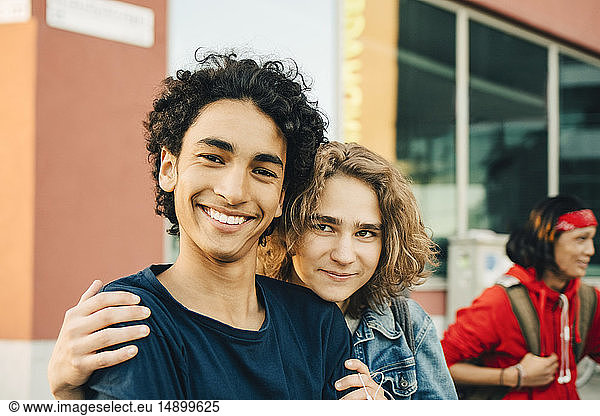 Portrait of smiling teenage boy with friend in city