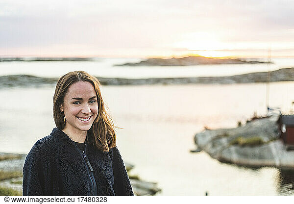 Portrait of smiling woman against sea during vacation