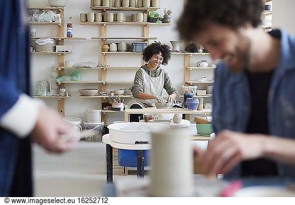 Portrait of smiling woman learning pottery in art class
