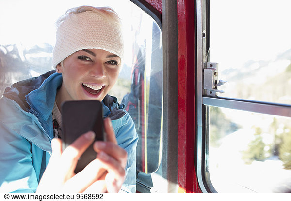 Portrait of smiling woman taking selfie in ski lift