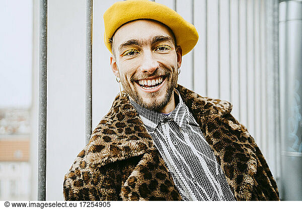 Portrait of smiling young man wearing leopard print coat