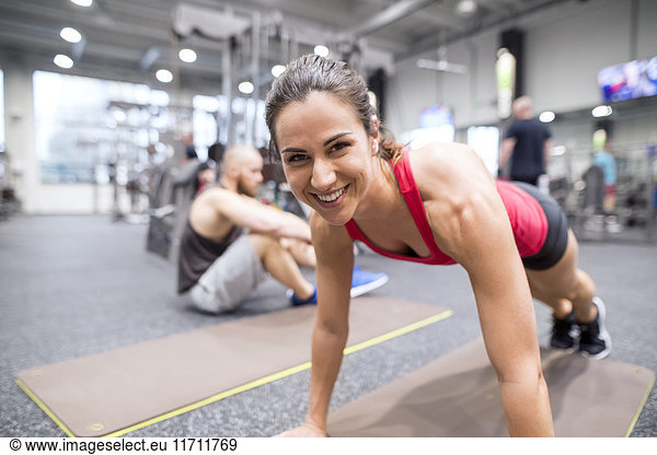 Portrait of smiling young woman exercising in gym