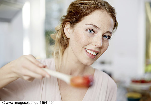 Portrait of smiling young woman in kitchen