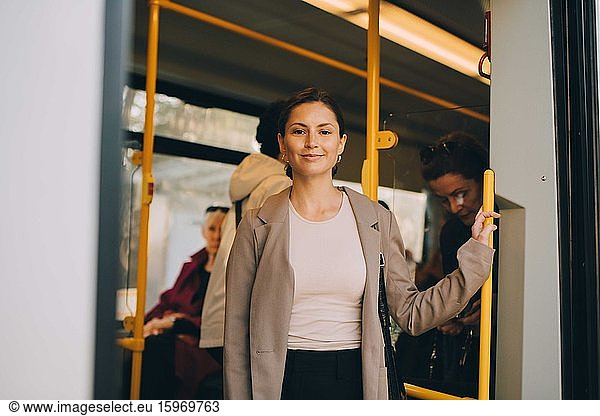 Portrait of smiling young woman in tram during city exploration