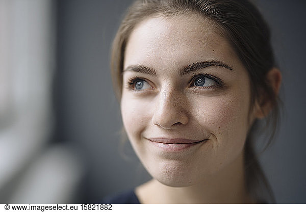 Portrait of smiling young woman looking at distance
