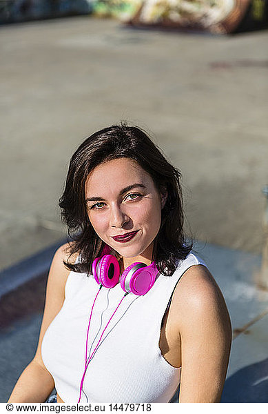 Portrait of smiling young woman with headphones in the city