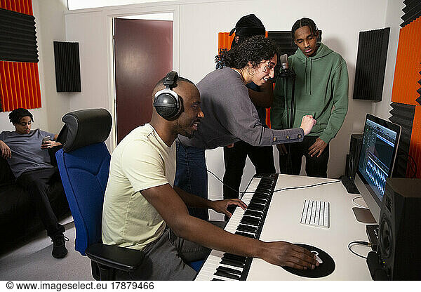 Portrait of sound engineers working with rappers in recording studio