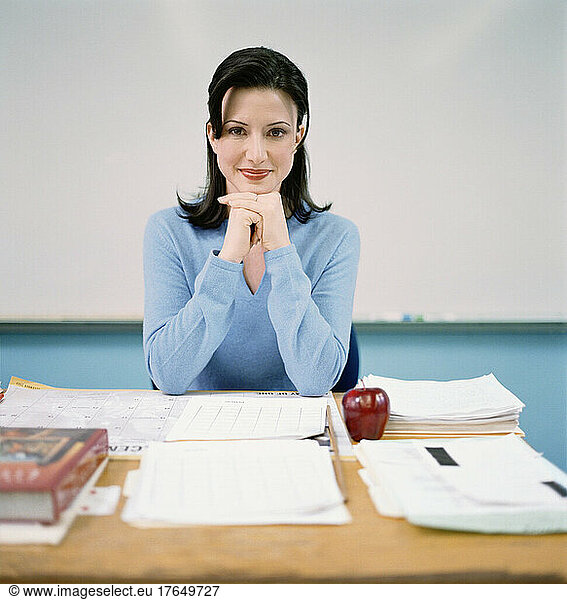 Portrait of teacher sitting behind desk