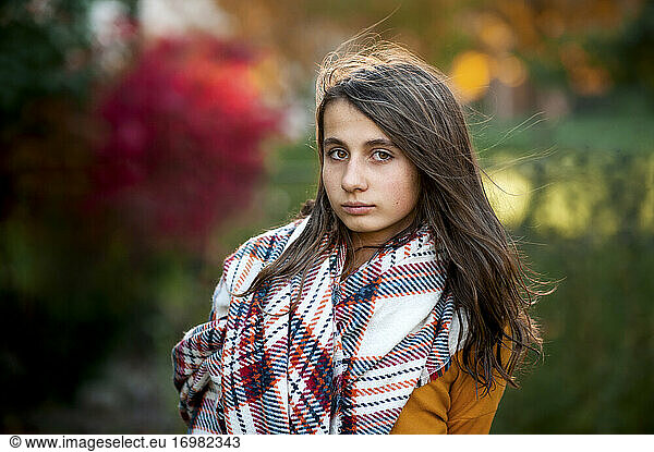 Portrait of teen girl 11-13 years old in warm clothes on fall day