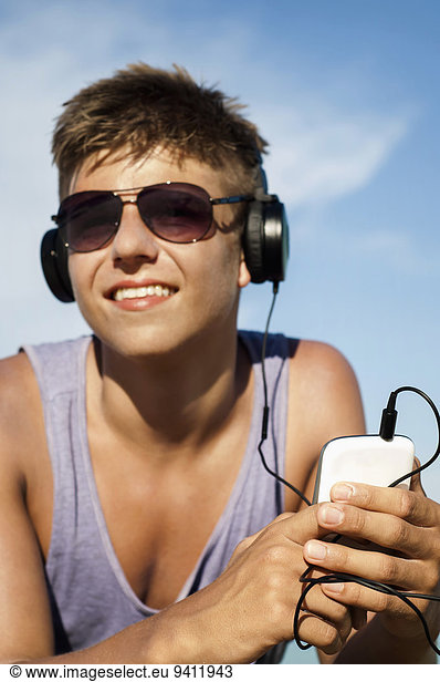 Portrait of teenage boy hearing music at beach  Koh Lipe  Thailand
