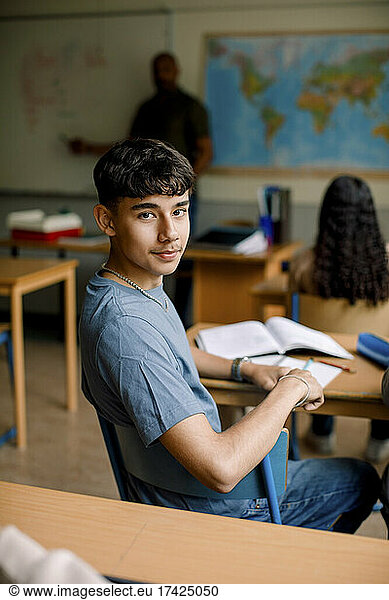 Portrait of teenage boy in high school classroom