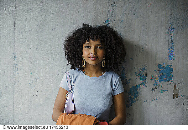 Portrait of teenage girl against wall
