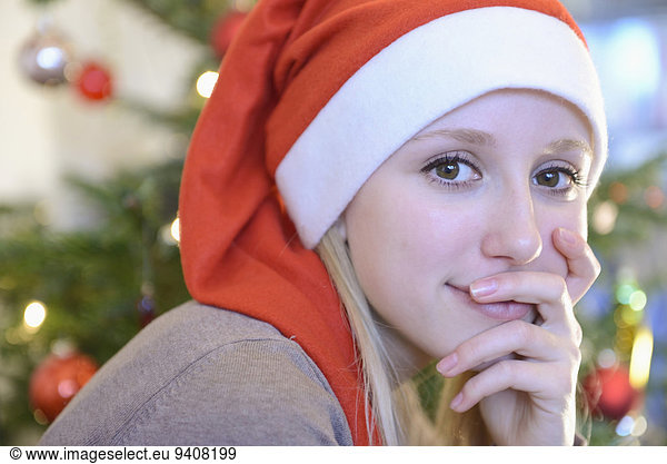 Portrait of teenage girl in front of christmas tree