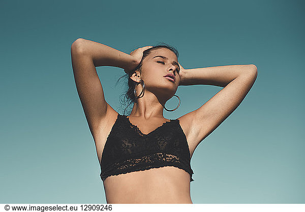 Portrait of teenage girl wearing black top against sky