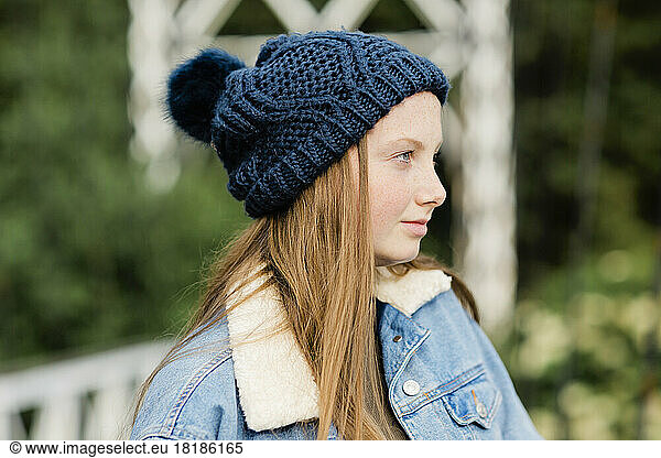 Portrait of teenage girl wearing woolly hat  looking sideways
