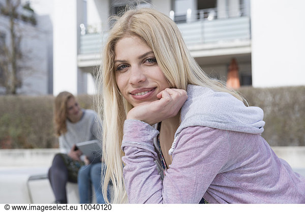 Portrait of teenage girl with her friends using digital tablet in the background  Munich  Bavaria  Germany