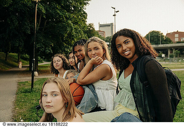Portrait of teenage girls sitting together at park