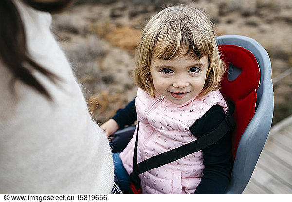 Portrait of toddler girl in child's seat of a bicycle