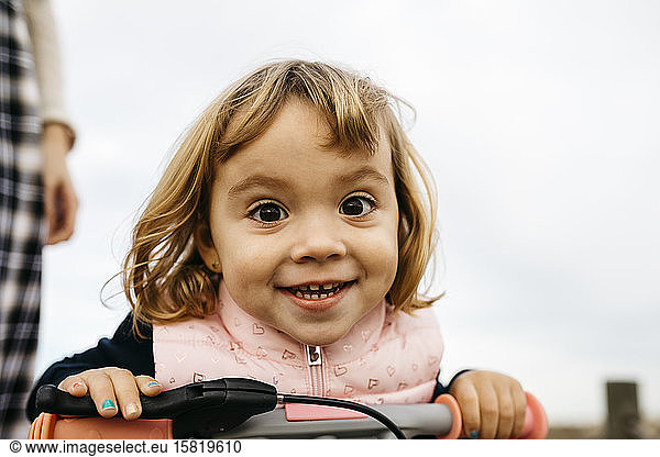 Portrait of toddler girl with balance bicycle