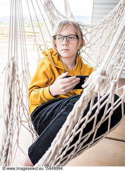 Portrait of tween in hammock listening to music