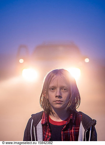 Portrait of tween with shoulder length hair backlit by headlights