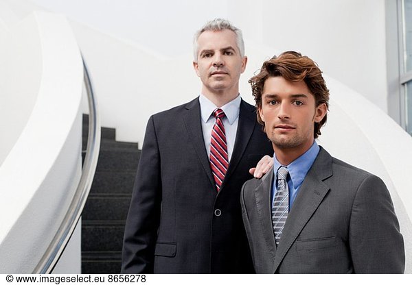 Portrait of two businessmen on office stairs