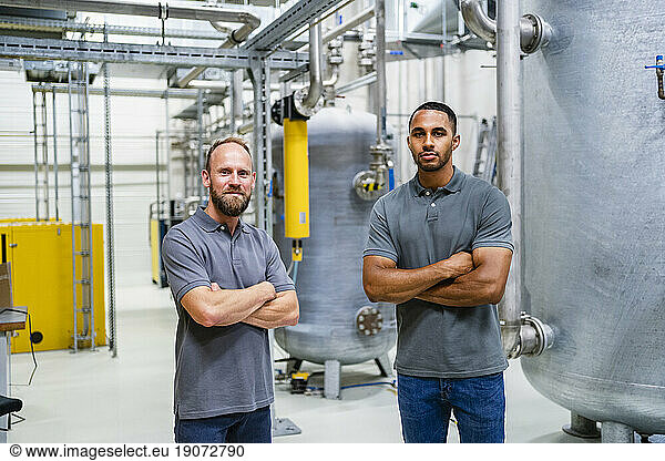 Portrait of two confident employees in factory