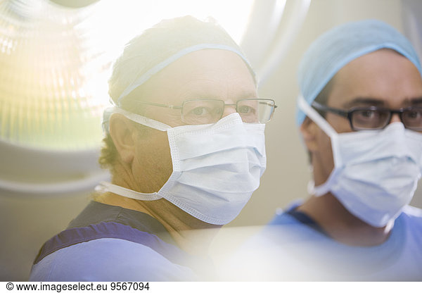 Portrait of two doctors wearing surgical caps  masks and glasses in operating theater