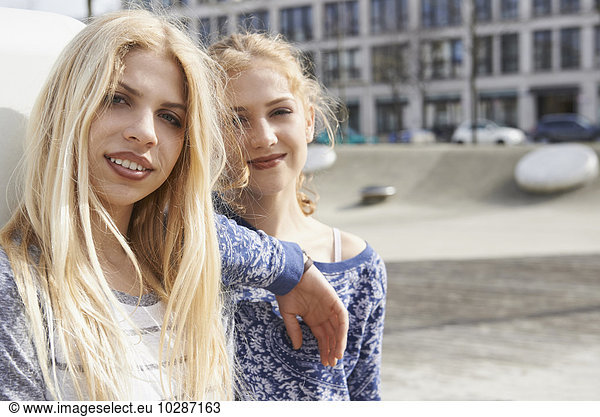 Portrait of two friends smiling in a playground  Munich  Bavaria  Germany