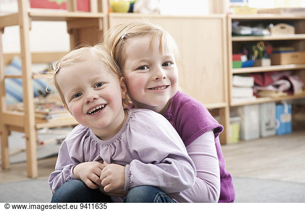 Portrait of two little sisters in kindergarten