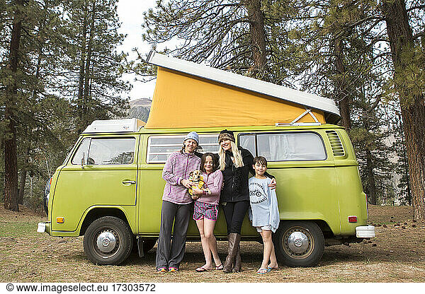 Portrait of two women  two children and dog in front of green VW van