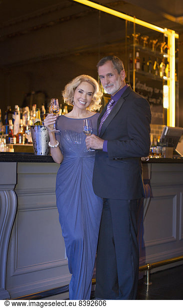 Portrait of well dressed couple drinking champagne in luxury bar