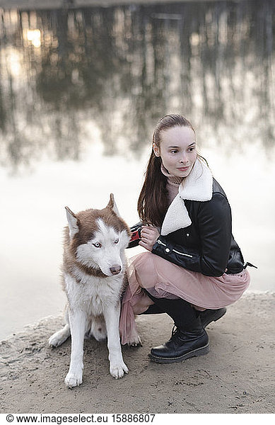 Portrait of woman and her husky at water's edge